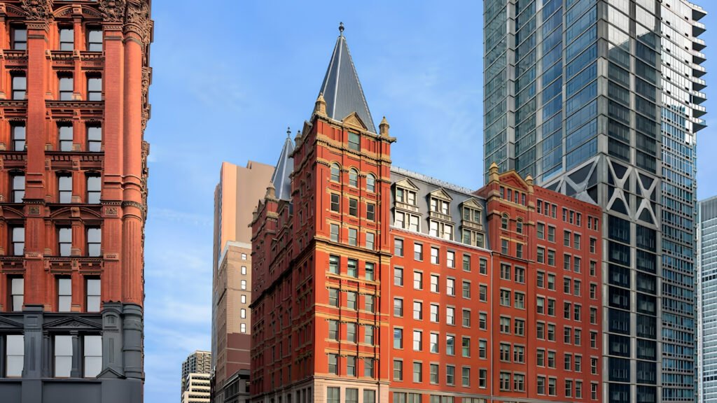 Soaring nine-story skylit atrium with historic iron balustrades inside The Beekman hotel.