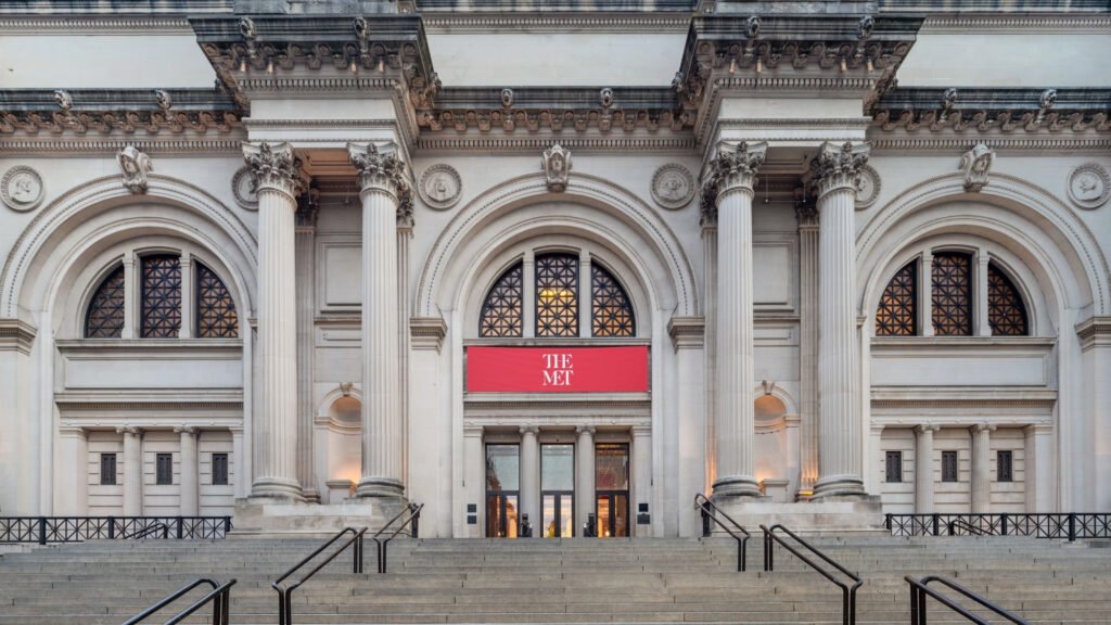 Grand exterior entrance and stone facade of The Metropolitan Museum of Art on Fifth Avenue, New York City.