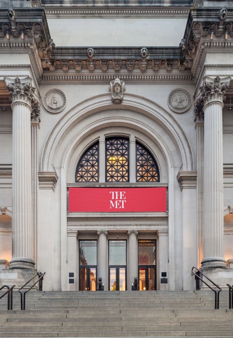 Grand exterior entrance and stone facade of The Metropolitan Museum of Art on Fifth Avenue, New York City.